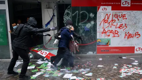 varias-personas-salen-escaparate-roto-tienda-evacuar-edificio-enfrentamientos-posteriores-manifestacion-paris_70